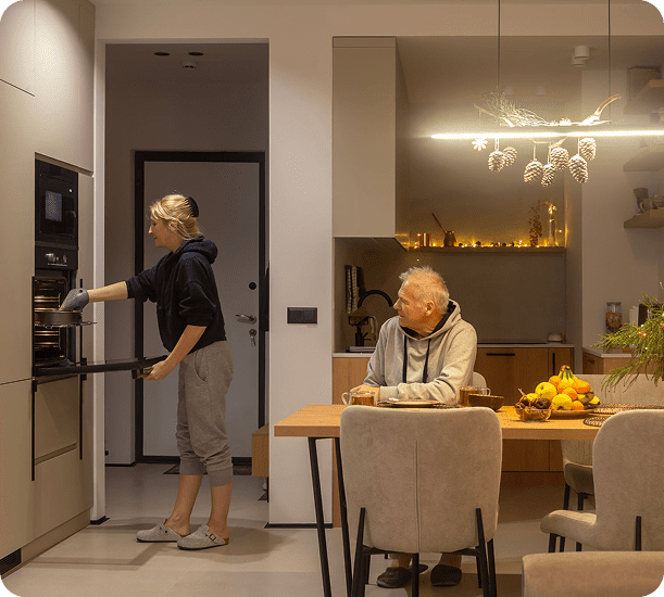 Woman cooking, man watching in cozy kitchen