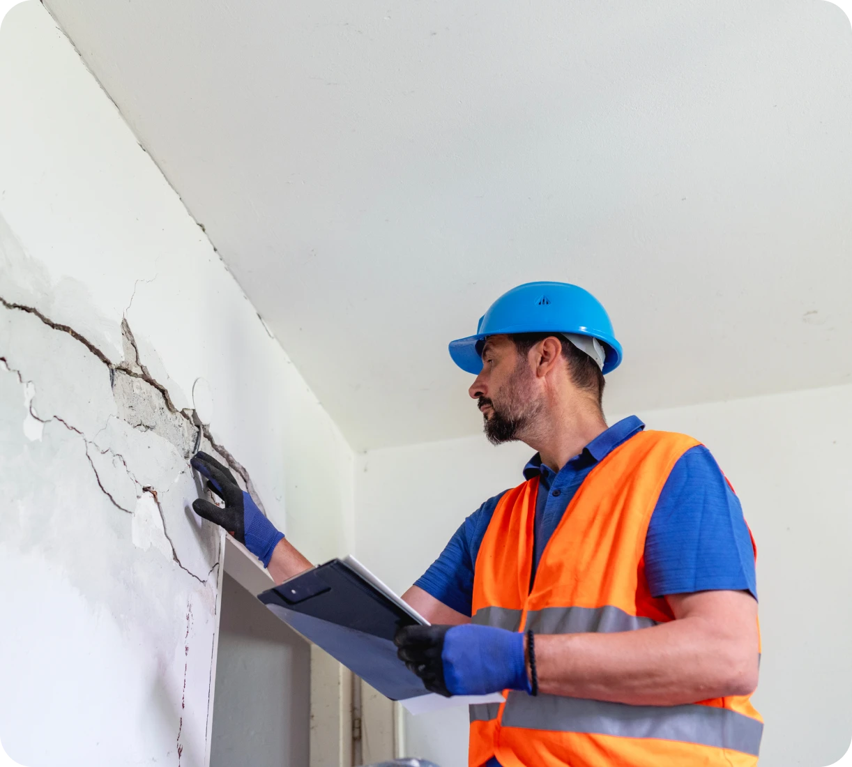 Construction worker inspecting wall crack