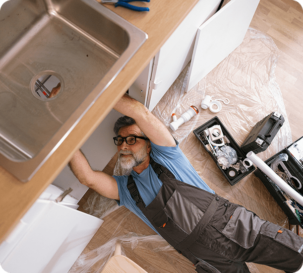 Man fixing sink plumbing pipes