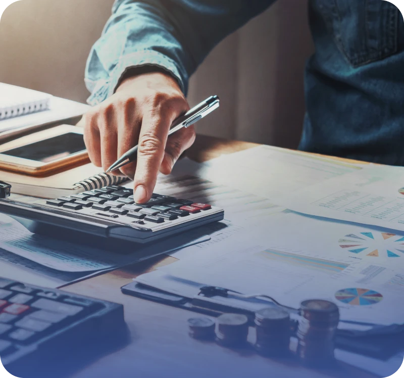 Person using calculator with documents on desk