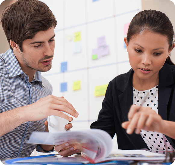 Colleagues discussing work at office desk